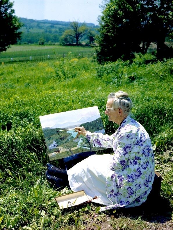庭で絵を描くグランマ・モーゼス　1946年　 写真：Ifor Thomas（ギャラリー・セント・エティエンヌ、ニューヨーク寄託） (C) 2021, Grandma Moses Properties Co., NY
