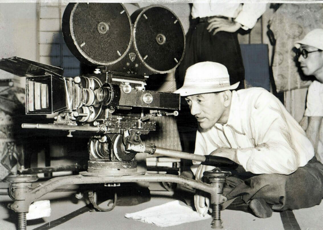 1952年、『お茶漬けの味』ロケ中にカメラを覗く小津安二郎。