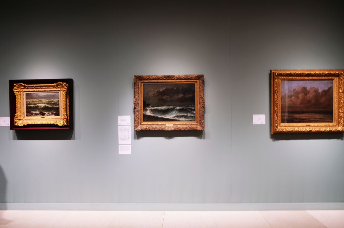 第五章「クールベの海」展示風景。左から、《波》1869年、《水平線上のスコール》1872-73年、《海》1875年。これらは、クールベが故郷のオルナンやスイス滞在中に描いたもの。海から遠く離れた場所でも、クールベは思い出を頼りに海の風景画を描きつづけていた。
