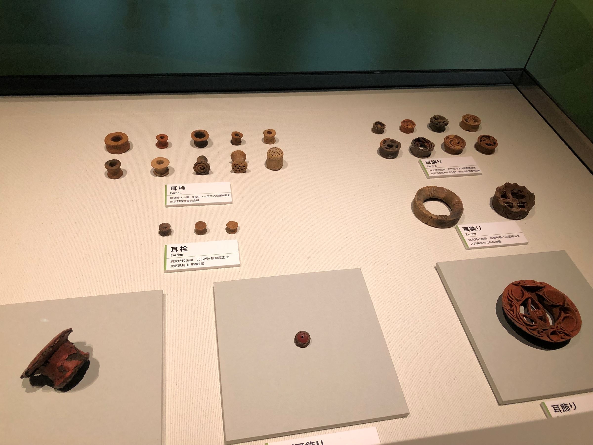 調布市下布田遺跡で発掘された土製耳飾り（右下）ほか、耳栓や耳飾り