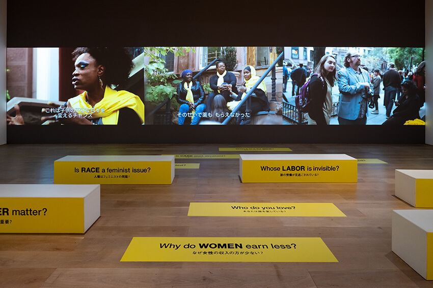 スザンヌ・レイシー《玄関と通りのあいだ》2013／2021年 3チャンネル・ビデオ、デジタルプリント 20分2秒（ビデオ） 本作はクリエイティブ・タイム（ニューヨーク）、ブルックリン美術館エリザベス・A・サックラー・センター・フォー・フェミニスト・ アートの協賛によって2013年に制作されました。 展示風景：「アナザーエナジー展：挑戦しつづける力―世界の女性アーティスト16人」森美術館（東京）2021年　撮影：古川裕也　画像提供：森美術館