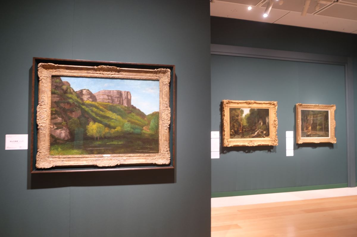 第一章「クールベと自然」展示風景。左はギュスターヴ・クールベ《岩山の風景、ジュラ》1856年 